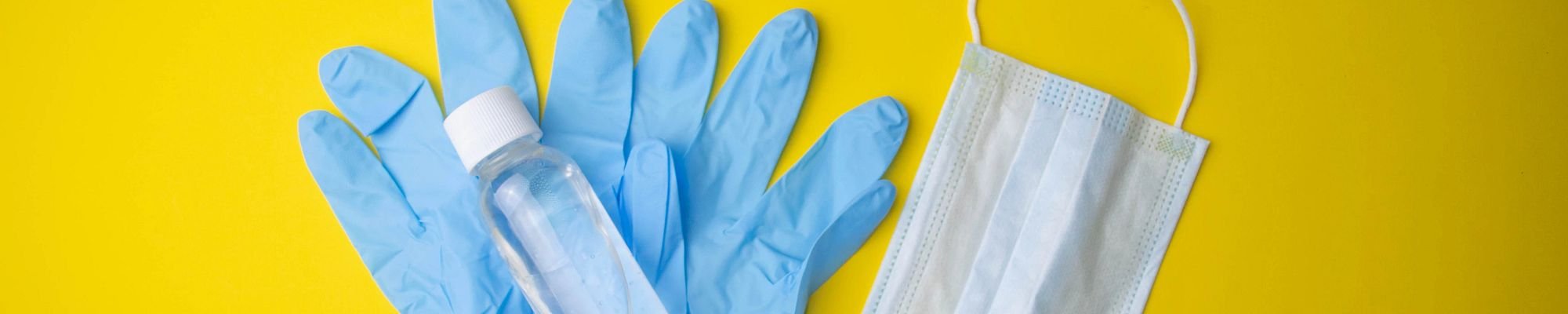 Blue Surgical gloves with hand sanitizer on them and a face mask - Carpet Innovations in Denver, CO